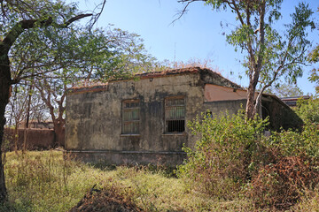 Mhaismal, MH, India, Dec 12, 2025 Abandoned old rural building surrounded by overgrown vegetation and trees in hill station area