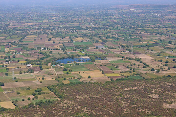Mhaismal, MH, India, Dec 12, 2025 High angle panoramic view of patchwork farmland, rural villages and small lakes across the valley