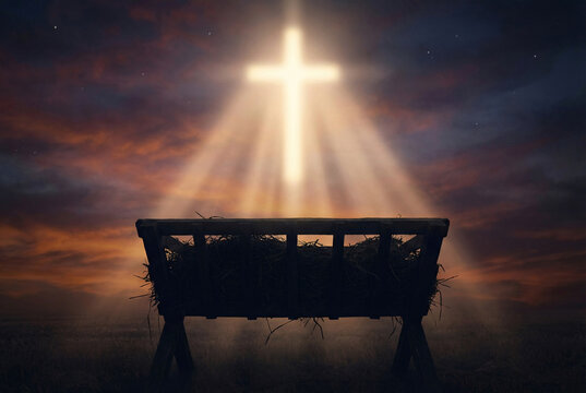 Holy cross light shining over empty manger at dusk sky, Christian nativity, Christmas hope and salvation concept.