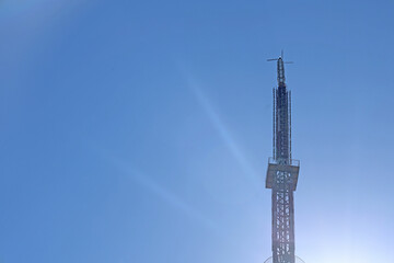 Mhaismal, MH, India, Dec 12: Extreme close-up of the metallic antenna structure and observation deck of the Doordarshan TV tower against a clear blue sky, with subtle lens flare.