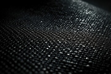 Close-up of black textured surface with shiny reflective dots and subtle gradient