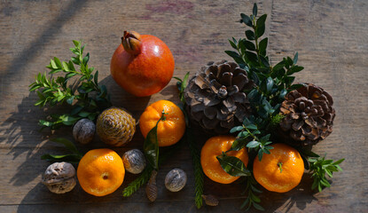 Tangerines and fir nuts on a board