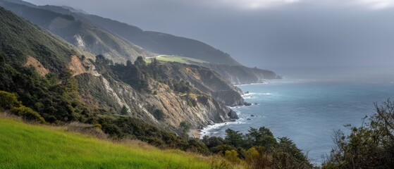 Coastal landscape with mountains and ocean under cloudy sky during daytime