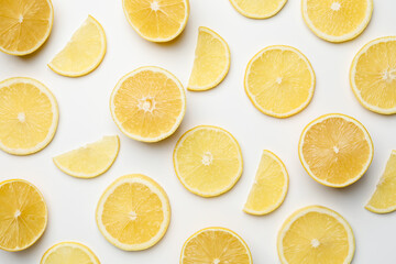 Fototapeta premium Pieces of fresh lemons on white background, flat lay