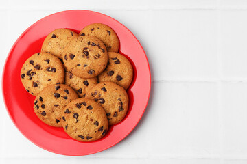 Delicious chocolate chip cookies on light tiled table, top view. Space for text