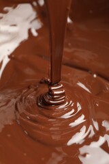 Tasty melted chocolate flowing down, closeup view