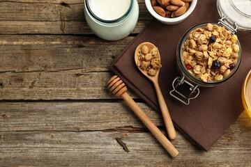 Tasty granola with dried fruits, nuts and milk on wooden table, flat lay. Space for text