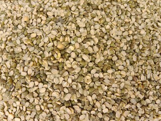 Top view of Split green garm or Split moong beans or green moong dal pile displayed in order on vendor's.Vigna radiata spilt pulse pile show for sale in the market. split Mung bean pattern background