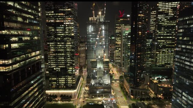 flight over night time illuminated singapore city downtown square construction site exterior aerial panorama 4k   
