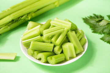 Fresh green cut celery on green background