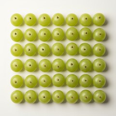 Fresh green grapes meticulously aligned in a neat square grid