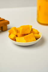 Ripe mango slice and cut in cube on a small white dish