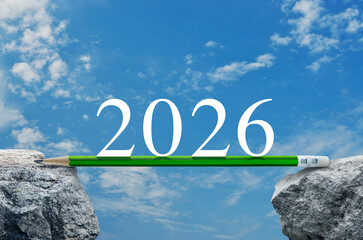 2026 white text with green pencil on rock mountain over blue sky with white clouds, Business success, strategy and planning concept, Happy new year 2026 education concept
