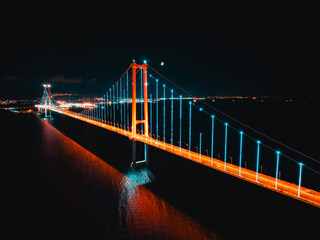 Osmangazi Bridge appears under evening light from a drone view as traffic flows across the water.