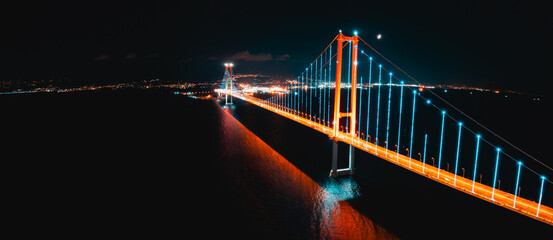 Osmangazi Bridge appears under evening light from a drone view as traffic flows across the water.