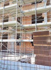 Multi-Story Building Construction with Scaffolding and Red Bricks