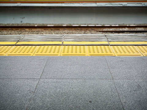 Yellow tactile paving on train station platform edge for safety