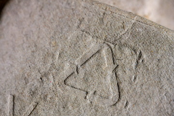 Natural brown paper pulp packaging texture featuring the universal recycling code 21, symbolizing environmental consciousness, sustainability, and responsible consumption.