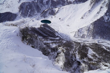A snow-covered mountain range in the Caucasus region near the Gudauri ski resort. Georgia. Snow-capped mountain peaks and steep slopes.