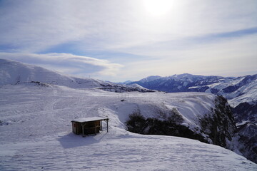 A snow-covered mountain range in the Caucasus region near the Gudauri ski resort. Georgia. Snow-capped mountain peaks and steep slopes.