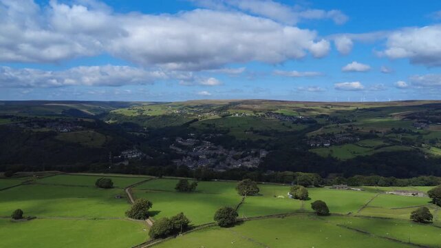 high aerial drone view of west yorkshire landscape in calderdale with hebden bridge and heptonstall visible between hills in summer