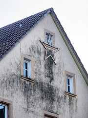 Weihnachtsstern an einer feuchten und stark verschmutzten Fassade