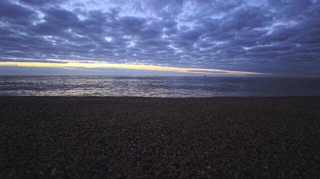 Low Angle Shoreline With Grainy Sand and Calm Sea at Dawn in Arenys Coast