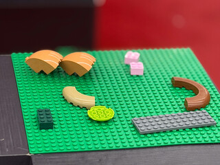 Fototapeta premium Colorful lego pieces on green baseplate