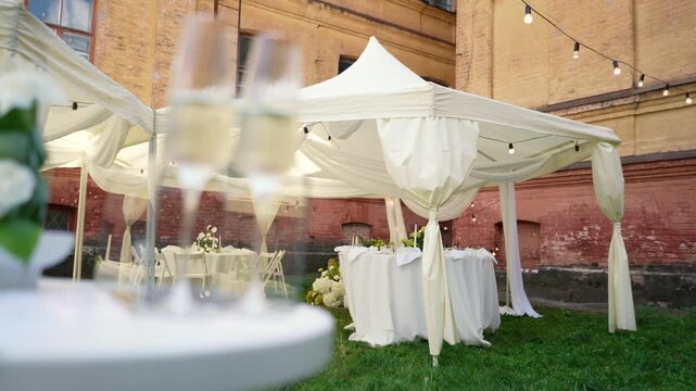 A very beautiful and stylish banquet table with a tent outdoors. Wedding decor and floral arrangements before the ceremony and celebration