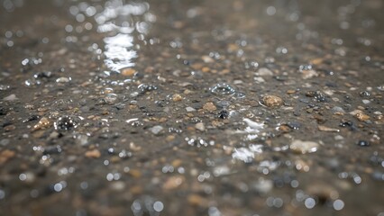 Closeup view of wet asphalt road surface with raindrops and blurred background