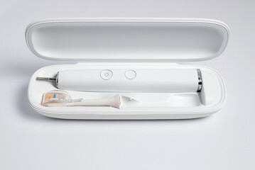 Modern electric toothbrush in open case isolated on white
