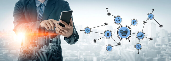 A businessman in formal attire interacts with a tablet, surrounded by digital icons that symbolize data networks against a city skyline, illustrating innovation and technology. Tessel