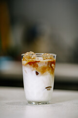 Minimalist iced coffee with milk and espresso swirl in a glass. Soft natural light, neutral tones, clean composition. Modern café lifestyle and refreshing drink concept.