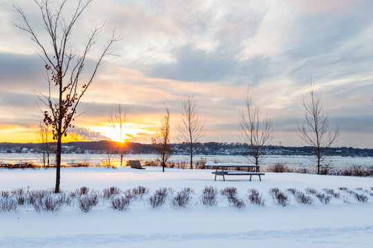 
Muted partly cloudy winter sunrise over the St. Lawrence river seen from the linear park on Champlain Boulevard, Quebec City, Quebec, Canada
