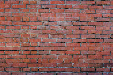 Obraz premium This is a close-up image of an old, weathered brick wall with varying reddish-brown tones. The rough texture and imperfect mortar between the horizontal rows of bricks fill the entire frame.