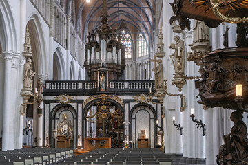Obraz premium Saint Salvator Cathedral: in Bruges, vaulted ceilings an elaborate altar with a raised pulpit, and a richly decorated organ loft. Statues of religious figures line the columns and walls,
