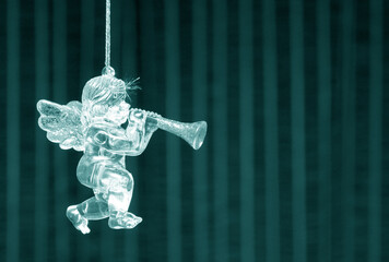 Glass angel on beautiful striped background as symbol of Christmas and New Year celebrations