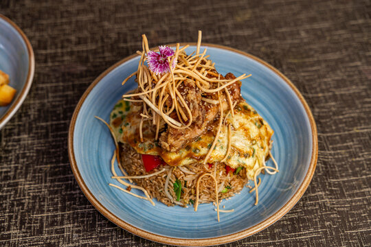Peruvian arroz chaufa with chijaukay chicken and egg omelet, traditional Chinese Peruvian chifa fusion cuisine.