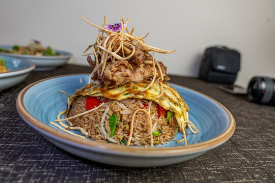 Peruvian arroz chaufa with chijaukay chicken and egg omelet, traditional Chinese Peruvian chifa fusion cuisine.
