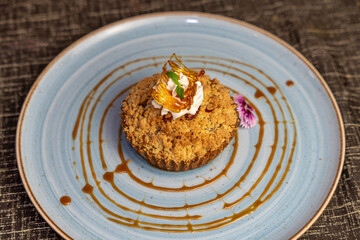 Crumble tart dessert topped with whipped cream and caramel, gourmet pastry with elegant restaurant presentation.