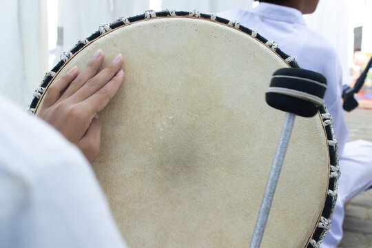 Traditional Hand Drum Performance: A Close-Up of a Tambourine Played in Indonesian Cultural Celebration