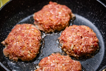 Rohes Burgerfleisch brät in einer Pfanne – Zubereitung von hausgemachten Patties
Raw burger meat fries in a pan – preparation of homemade patties