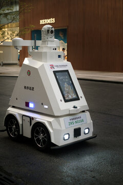 Shenzhen,China - December 2, 2025:Autonomous police security robot patrolling modern urban street. Advanced robotic law enforcement technology ensuring public safety in smart city environment.