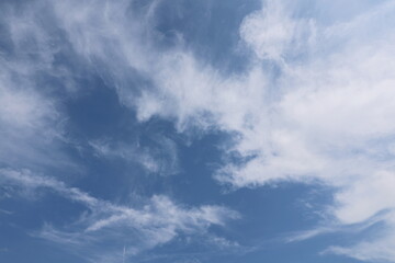 The sky is full of Cirrus clouds. The sky blue. The atmosphere of the sky in summer. High-level clouds are characterized by thin, white streaks that resemble hairs, fibers, or feathers, ice crystals
