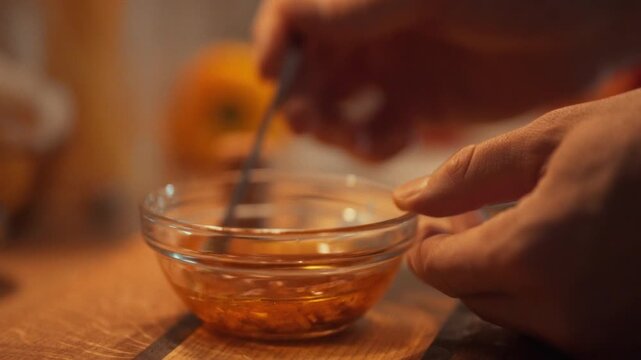 A cook stirs a homemade sauce mixture of chopped garlic, oil, and seasonings, releasing a savory aroma, to create a delicious marinade dressing with a smooth texture