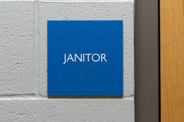 Blue janitor sign on wall