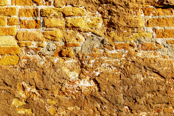 Textured ancient brick wall with weathered surface and vibrant colors