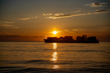 Cargo ship in the sea at sunrise