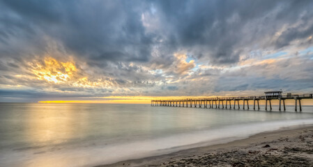 Sunset with dramatic clouds in sky over the Gulf of America formerlly the Gulf of Mexico at the Venice Fishing Pier in Venice Florida USA