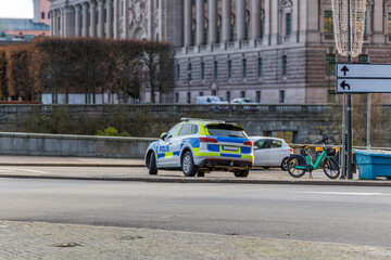 Obraz premium Swedish Police Car and Scooter near Parliament Building